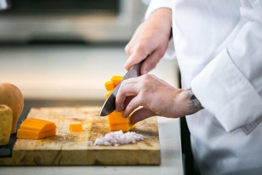 A person cutting cheese on a wooden board. 4