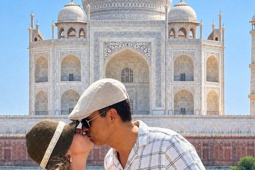Ett par kysser varandra framför Taj Mahal. 3