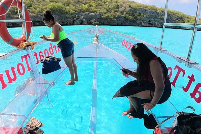 A boat with clear blue water, a lifebuoy, and a person holding a bag. 3