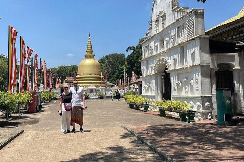 A temple with a golden dome, white walls, and flags. 5