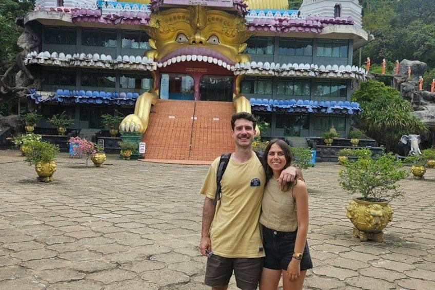 A temple with a large golden statue, a tiled roof, and a stone pathway. 4