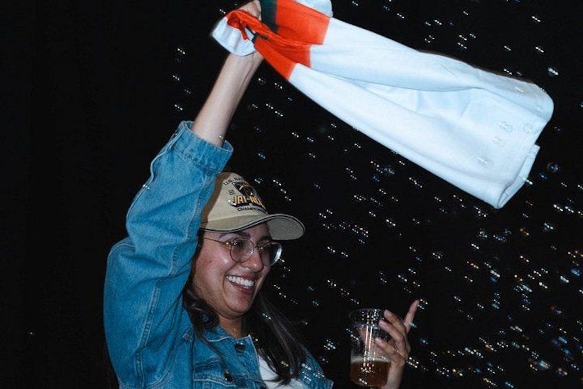 A person holding a white and orange object, possibly a bag, with a dark background. 4