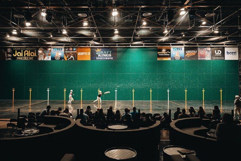 A badminton court with players, audience, and banners. 1