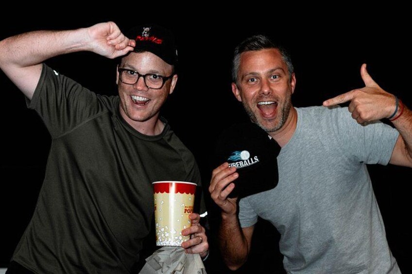 Two people holding a large cup and a microphone with the word 'Fireballs' on it. 5