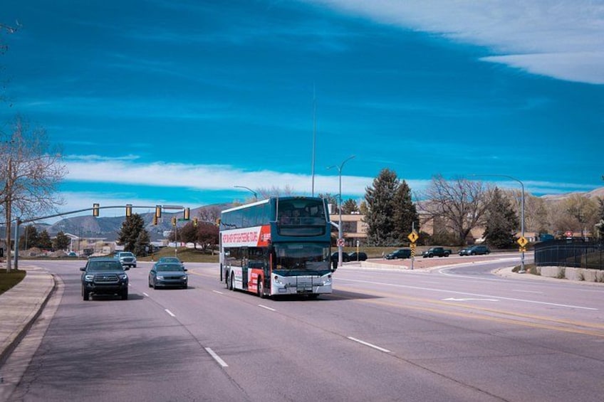 A multi-lane road with a bus, cars, and traffic lights. 5