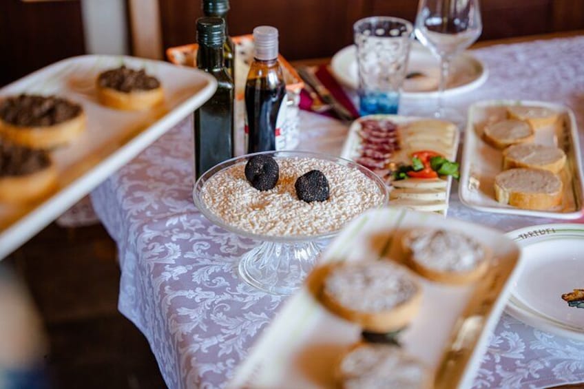 A table with various food items, including a dish with blackberries and a plate of sliced bread. 3