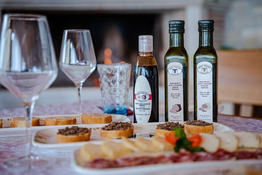 A table with various food items, wine glasses, and bottles of wine. 5
