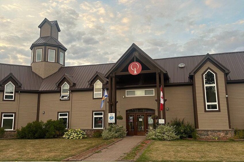 A two-story building with a brown facade, a central entrance, and a small tower-like structure. 3