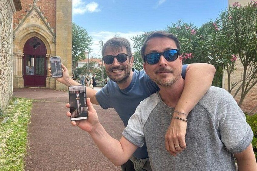 Dos personas tomándose un selfie con un edificio histórico de fondo. 2