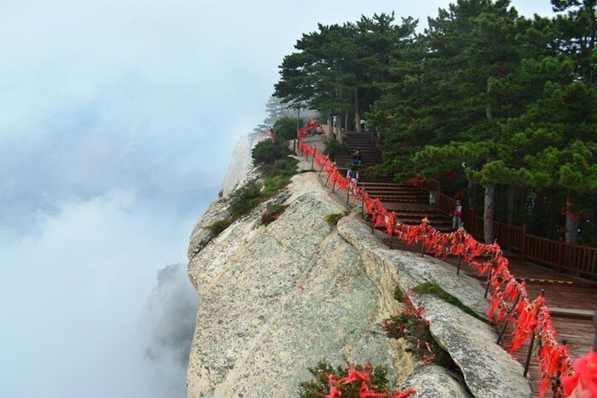A rocky mountain path with red barriers and steps leading up. 1