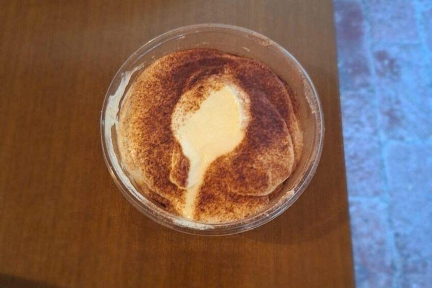 A cup of coffee with a latte art design on a wooden table. 4