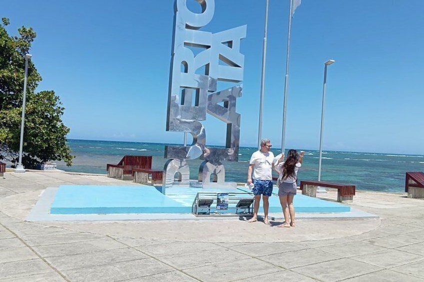 Una gran escultura al aire libre con la palabra 'RIO' y una persona de pie cerca. 3