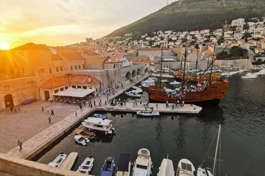 A harbor with boats, a large ship, and a town in the background. 1