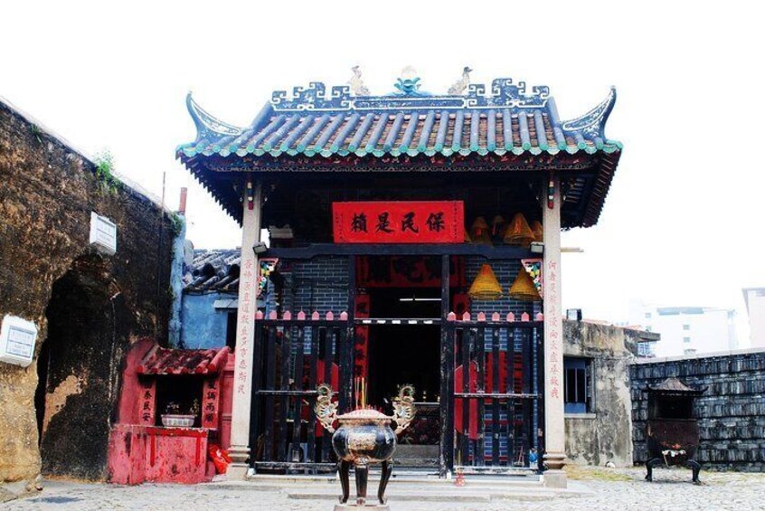 A traditional Chinese building with a tiled roof and red signage. 4
