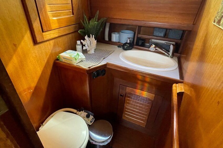 Une petite salle de bain comprenant des toilettes, un lavabo et des placards de rangement. 5