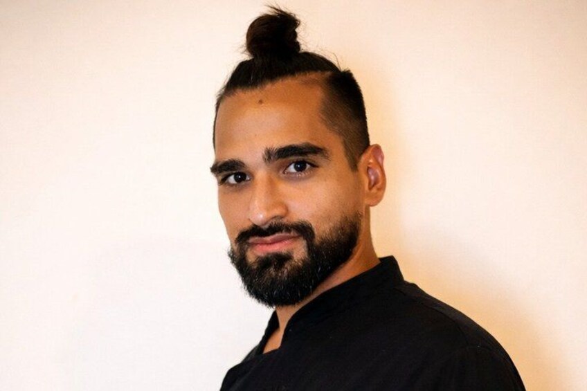 A person with a high ponytail hairstyle wearing a black shirt. 1