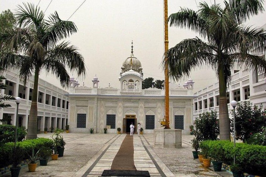 A grand building with a dome, palm trees, and a central walkway. 3