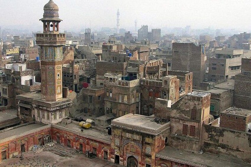 A densely packed urban area with historic architecture, including a prominent minaret and a large open courtyard. 5