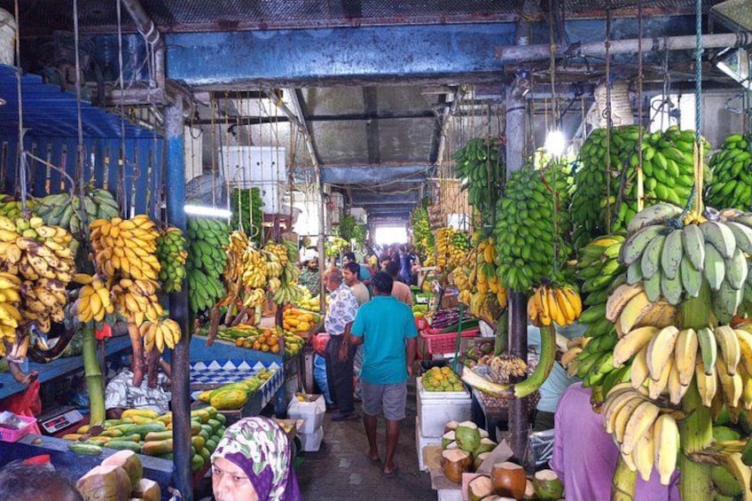 A market with hanging bananas and other fruits. 3