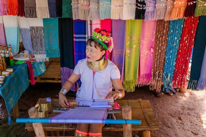 A person weaving colorful textiles at a traditional loom. 4