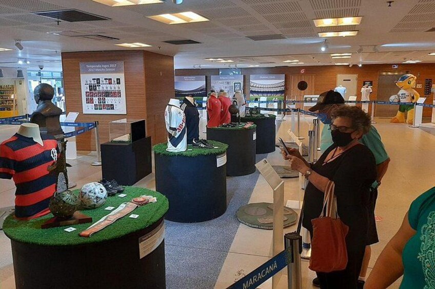 A sports store with mannequins dressed in sports attire, a soccer ball, and a display of sports equipment. 5