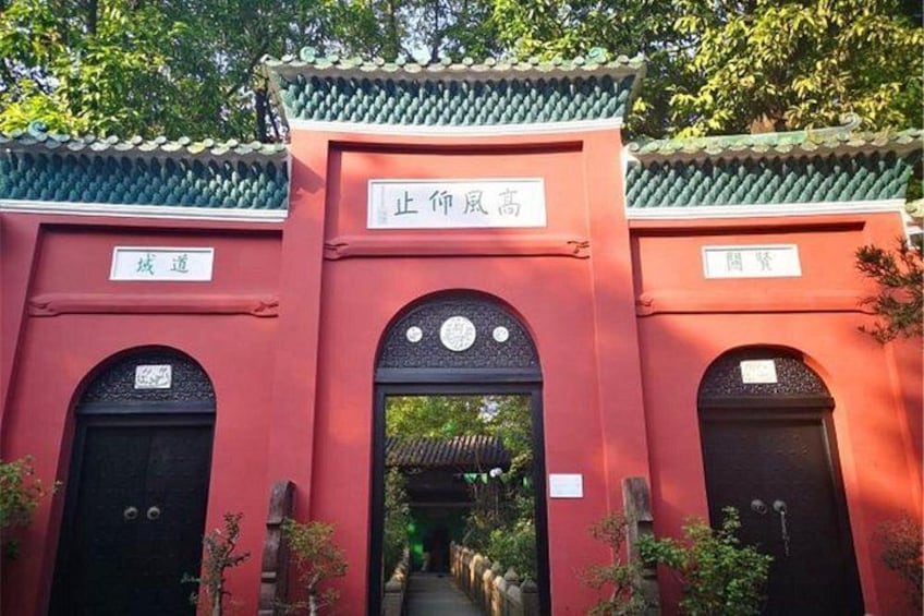 Ein traditionelles Tor mit chinesischen Schriftzeichen, einem Ziegeldach und einem Weg hindurch. 1