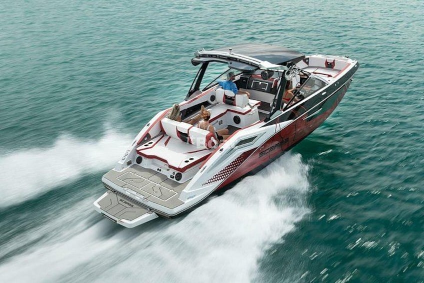 Een speedboot met een rood-wit kleurenschema, een overdekte cabine en een kielzog. 4