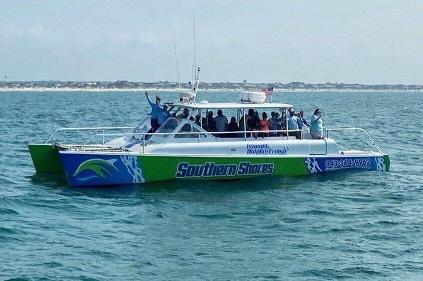 A boat with 'Southern Shores' and 'Island's Dolphin Cruise' written on it, sailing on water. 3