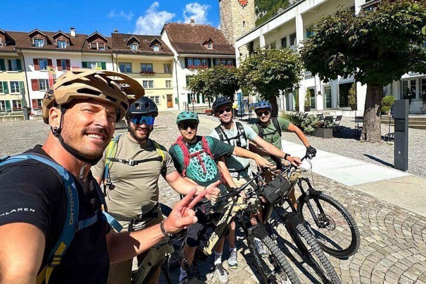 Un groupe de cyclistes sur une rue pavée, avec des bâtiments historiques en arrière-plan. 4