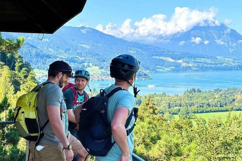 Un groupe de randonneurs sur un sentier de montagne, avec un lac et des montagnes en arrière-plan. 3