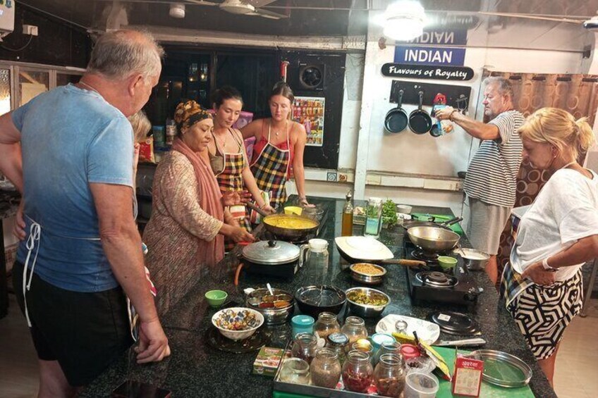 Un grupo de personas cocinando en una cocina, con diversos utensilios y productos sobre la encimera. 5