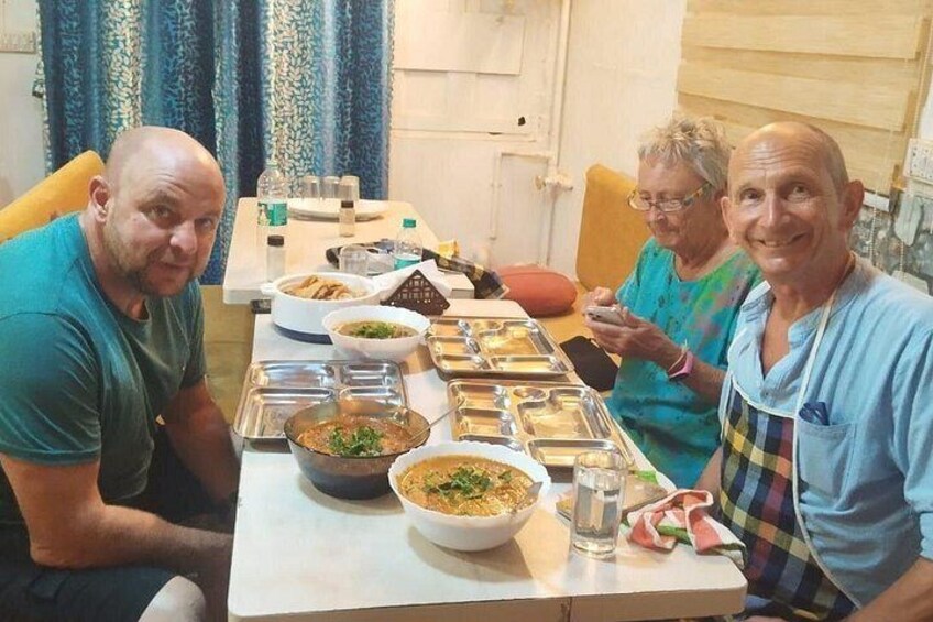 Four people seated at a table with various dishes and a house-shaped cookie. 2