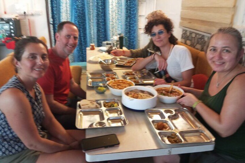 Four people sitting at a table with food containers and a smartphone. 2