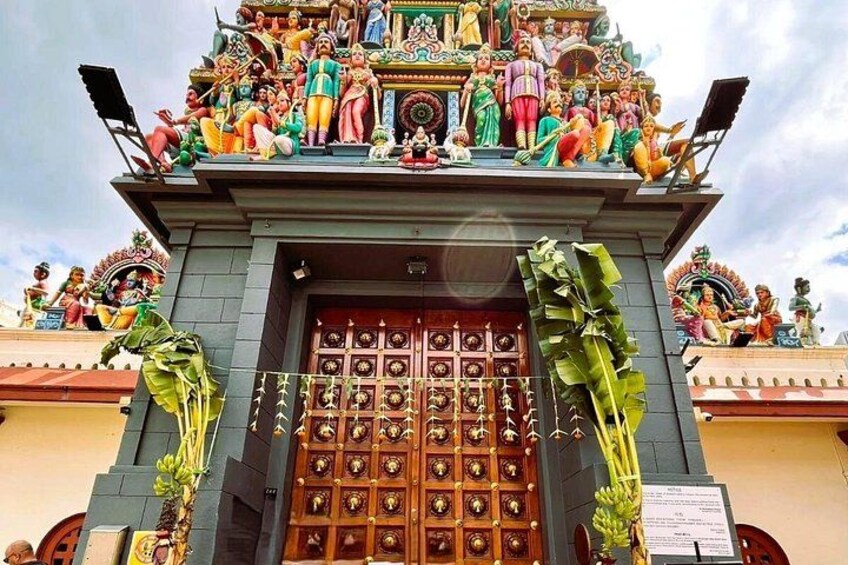 L'ingresso di un tempio con un'ampia porta in legno, elaborate sculture e statue di divinità sul tetto. 2