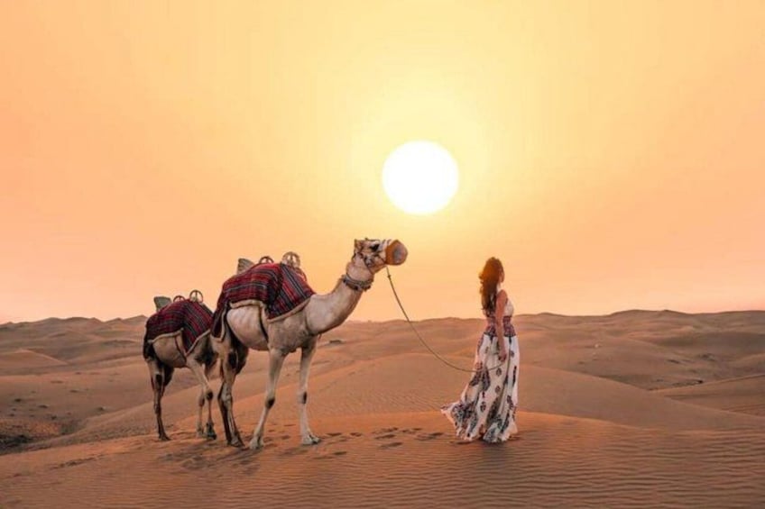 Wüstenlandschaft mit einem Kamel und einer Person in einem weiten Kleid. 1