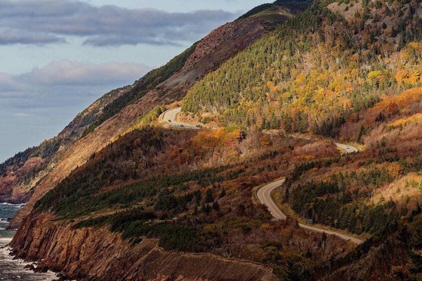 A winding mountain road, autumn foliage, and a coastline. 1