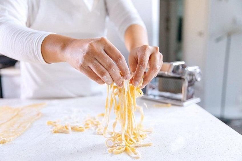 A person making pasta on a kitchen counter. 1