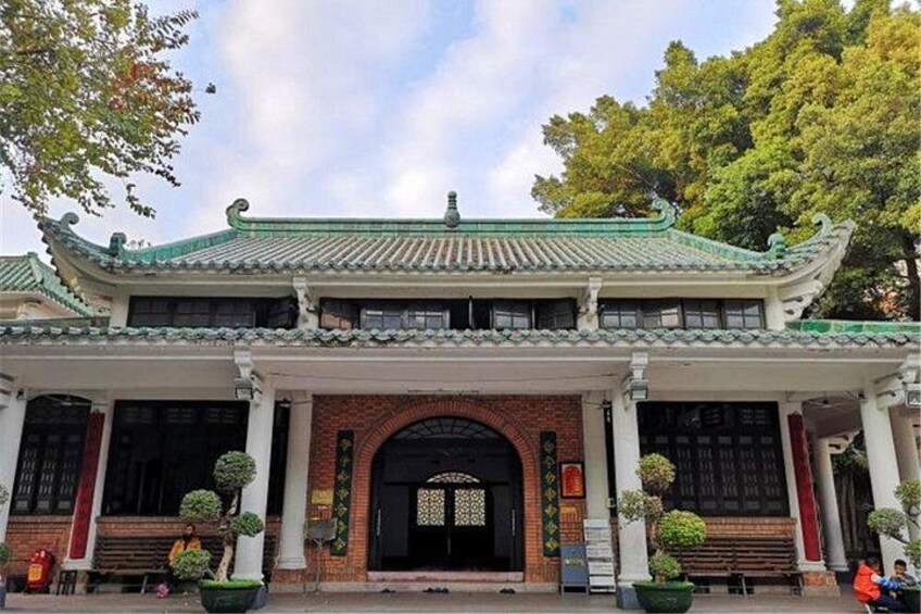 A traditional Chinese building with a tiled roof, brick walls, and a black gate. 2