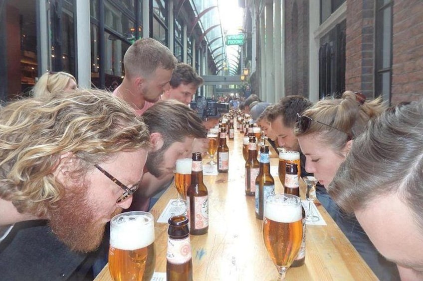Eine Gruppe von Personen sitzt an einem langen Tisch mit mehreren Bierflaschen. 5