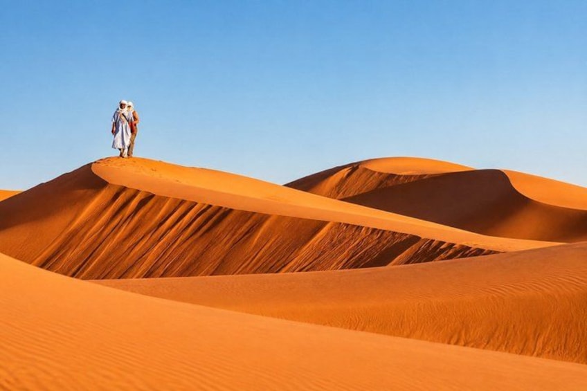 A person standing on a sand dune in a desert landscape. 3