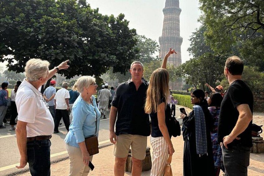 A group of people standing outdoors with a tall tower in the background. 4