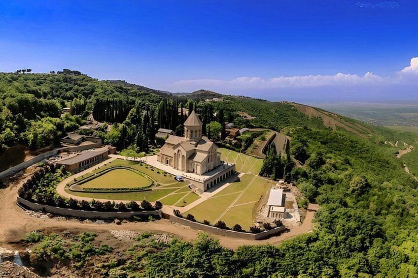 Un complesso storico di chiese circondato da vegetazione lussureggiante e dolci colline. 2