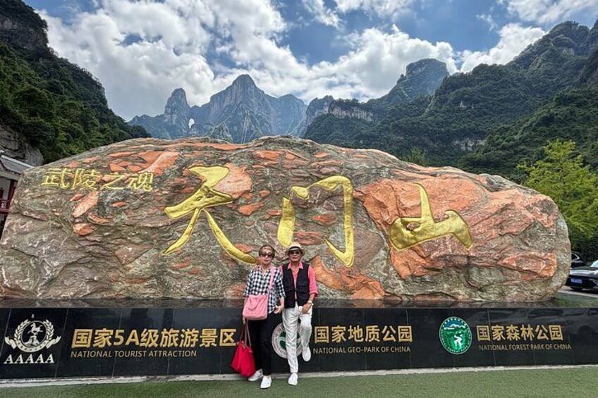 A large rock with golden Chinese characters and a sign for the National Tourist Attraction. 4