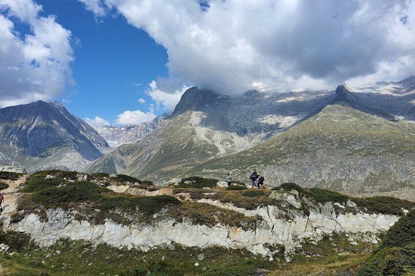 A mountainous landscape with a person hiking, rocky terrain, and a valley. 5