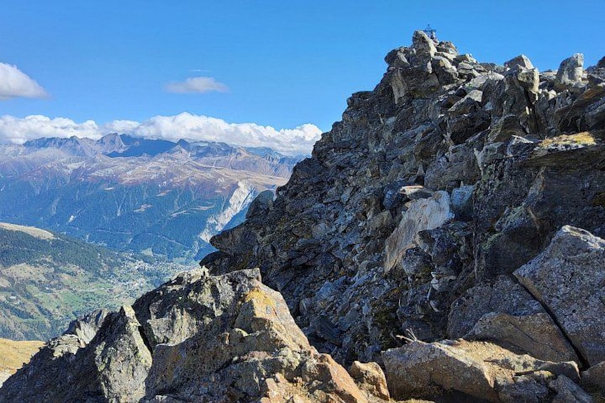 A rugged mountain peak with rocky terrain and a distant valley. 2