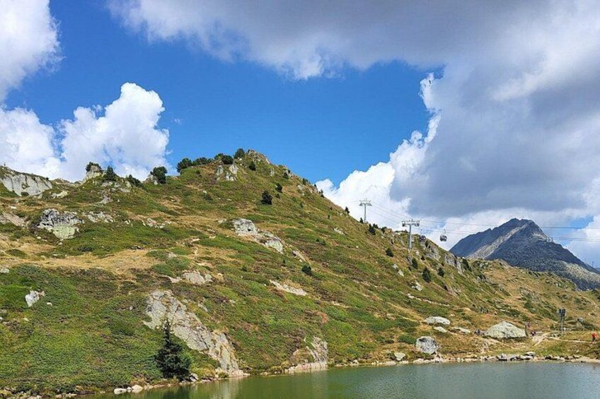 A mountainous landscape with a lake, a clear sky, and a distant mountain peak. 3