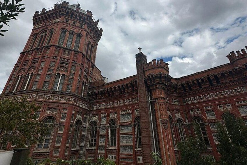 A large brick building with arched windows and a tower. 3