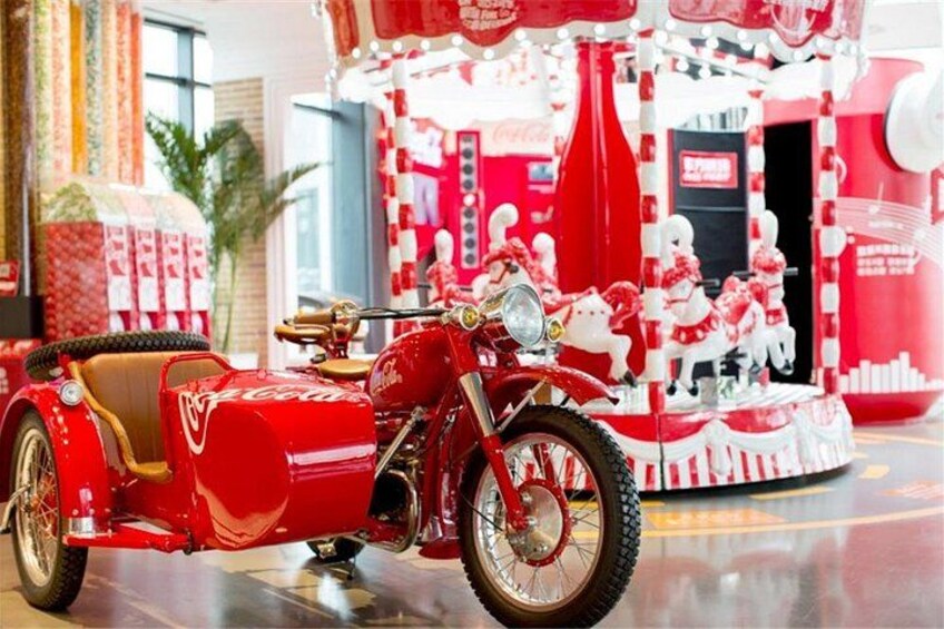 A red motorcycle with a sidecar, a carousel with red and white decorations, and a Coca-Cola sign. 4
