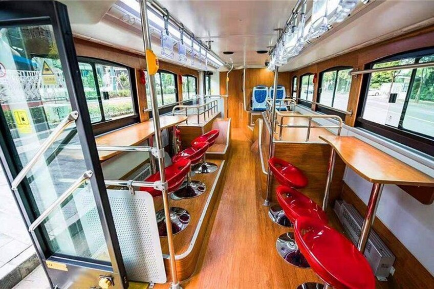 A train interior with wooden flooring, red seats, and windows. 3