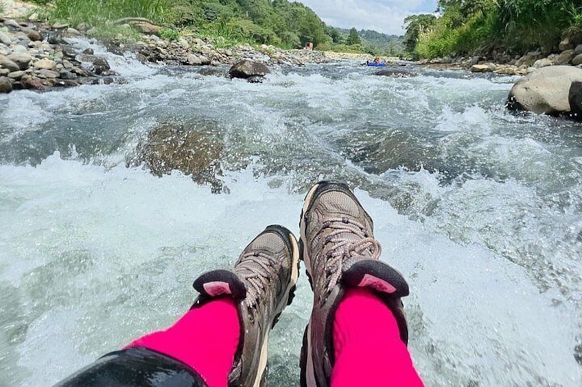 Un paio di scarponi da trekking su un letto di fiume roccioso con acqua che scorre. 2